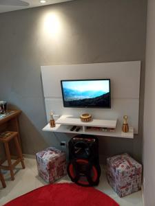 a room with a tv on a wall with boxes at Apartamento Lindíssimo e Moderno próximo a praia in Praia Grande