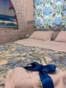 Un dormitorio con una cama con una cinta azul. en B&B 091, en Palermo