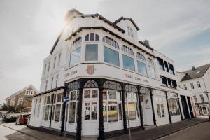 een wit gebouw met ramen aan een straat bij Hotel Villa Ems in Borkum