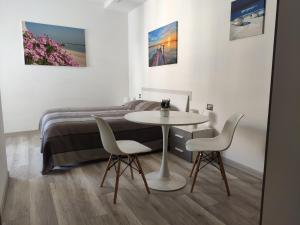 雷卡納蒂的住宿－Affittacamere Rosita Recanati，卧室配有一张床和一张桌子及椅子