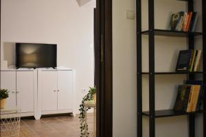 a living room with a television and a book shelf at At the core of the city next to Gallerius Palace in Thessaloniki