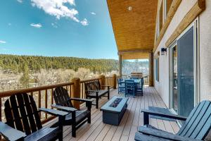 a deck with chairs and tables on a house at Riverfront Lodge in Pagosa Springs