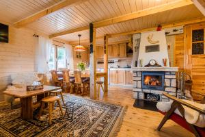 a kitchen and dining room with a fireplace in a house at Domek Lesinówka in Cisna