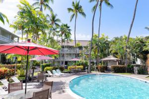una piscina in un resort con sedie e ombrellone di Kona Islander Inn # 219 a Kailua-Kona