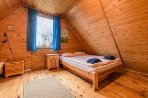 a bedroom with a bed in a wooden cabin at Domek Lesinówka in Cisna