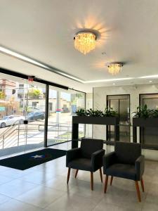 a lobby with two chairs and a large window at Edifício ABEPOM in Florianópolis