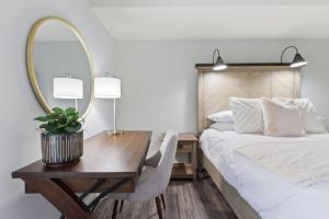 um quarto com uma cama e uma secretária com um espelho em Mountain Walk Chalet Across From Blue Mtn Village em Blue Mountains