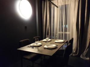 uma mesa de jantar com cadeiras e uma luz na parede em BLACKNIGHT Apartment - Self Check-In 24h em Breslávia