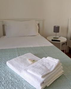 una pila de toallas sentadas encima de una cama en Raffaello, en Iesi