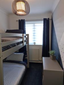 a bedroom with two bunk beds and a window at Stunning 2 bed house near coastal path/lake/beach in Llanelli