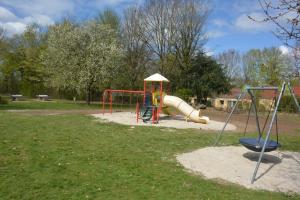 ein Spielplatz mit Rutsche in einem Park in der Unterkunft Vakantiehuis Rosa in Simpelveld