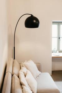 una lámpara sentada junto a un sofá en la sala de estar en Grad Štanjel House en Štanjel