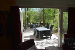 eine offene Tür zu einer Terrasse mit Tisch und Stühlen in der Unterkunft Vakantiehuis Rosa in Simpelveld