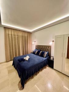 a bedroom with a large bed with a blue blanket at luxury studio-Haut standing MAARIF in Casablanca