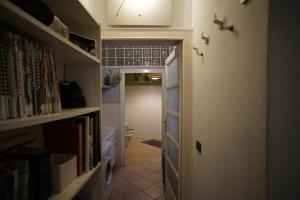 un pasillo con una puerta a una habitación con libros en Appartamento moderno a 2 passi dal Duomo di Parma, en Parma