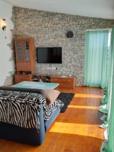 a living room with a tv on a brick wall at loren in Pirovac
