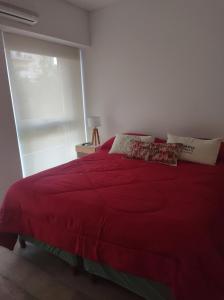 a bedroom with a red bed with a window at Barrio Norte 2 ambientes in Buenos Aires