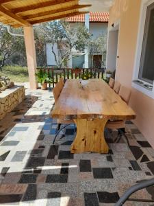 a wooden table on a patio with chairs at loren in Pirovac