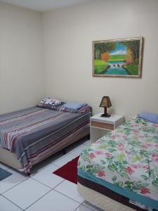 a bedroom with two beds and a picture on the wall at Porto dos Lencóis - Chalé Tipo Apartamento in Barreirinhas