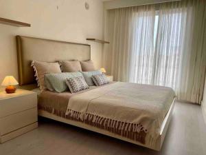 een slaapkamer met een groot bed en een raam bij Lovely 3-bedroom townhouse with shared pool in Estepona
