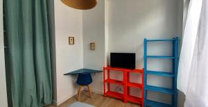 a room with a desk and a television on a shelf at Histoire de Loire - RABELAIS in Saumur