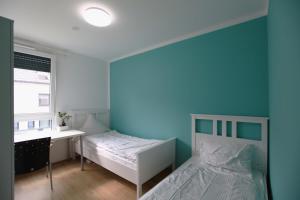 ein Schlafzimmer mit 2 Betten und einer blauen Wand in der Unterkunft Messezimmer Hannover / Private rooms for exhibitions in Hannover