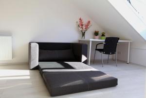 ein Sofa in einem Zimmer mit einem Tisch und einem Stuhl in der Unterkunft Messezimmer Hannover / Private rooms for exhibitions in Hannover