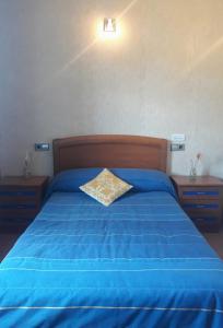 a blue bed with a pillow on top of it at O DESCANSO DE MANDUCA in Mazaricos