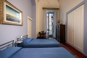 een slaapkamer met twee bedden en een schilderij aan de muur bij Domus Decumana in Napels