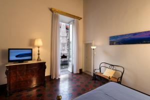 een slaapkamer met een bed en een televisie op een dressoir bij Domus Decumana in Napels