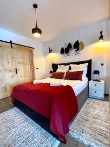 1 dormitorio con 1 cama grande con manta roja en Dream Studio Silver Mountain, en Poiana Brasov