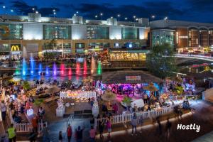 een menigte mensen die 's nachts rond een winkelcentrum lopen bij Wesley Gate Apartments - by Hostly in Reading