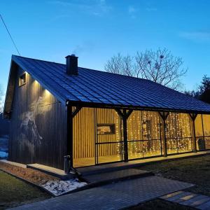 duży drewniany budynek z czarnym dachem w obiekcie Na Zakręcie - Domek Loft w mieście Błędowo +14 zdjęć