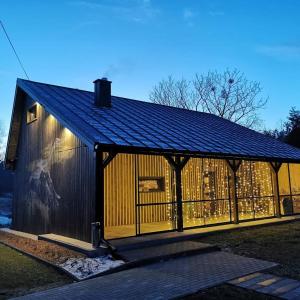 un gran edificio de madera con techo negro en Na Zakręcie - Domek Loft, en Błędowo