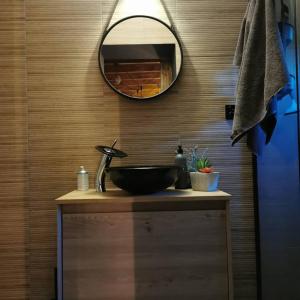 łazienka z czarną umywalką i lustrem w obiekcie Na Zakręcie - Domek Loft w mieście Błędowo