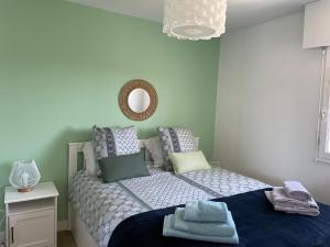 um pequeno quarto com uma cama e um espelho em Appartement T3 vue mer Sauzon balcon et parking privé em Sauzon
