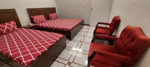 ein Zimmer mit einem Bett und einem Stuhl darin in der Unterkunft Palace inn Guest House in Karatschi