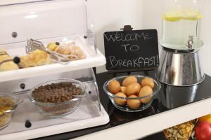 ein Kühlschrank mit etwas Essen und ein Willkommensschild für das Frühstück in der Unterkunft Mecla Suites in Neapel