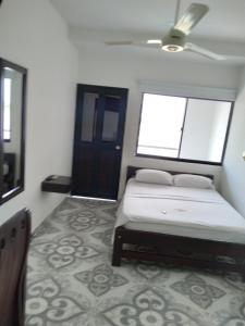 a bedroom with a bed and two windows at HOTEL DORADO PUERTO BERRIO in Puerto Berrío