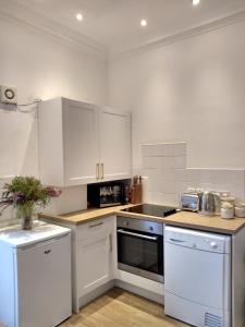 a kitchen with white cabinets and a stove top oven at Stylish two bedroom apartment in St Andrews centre in St. Andrews