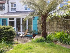 a house with a palm tree and a table at The Ark Cottage in Par
