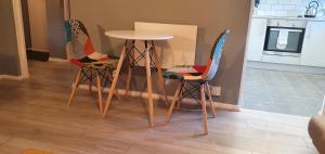 trzy krzesła i stół w kuchni w obiekcie The Court w mieście Braintree