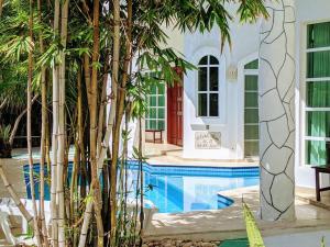 una casa con piscina con árboles delante en 9br 6ba Large groups! Best location in town Walk to beach, 5th ave Cozumel ferry, shopping, nightlife! Roof plunge pool!! Castillo Playacar Fase 1 25max, en Playa del Carmen