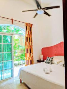 Un dormitorio con una cama y una ventana grande en 9br 6ba Large groups! Best location in town Walk to beach, 5th ave Cozumel ferry, shopping, nightlife! Roof plunge pool!! Castillo Playacar Fase 1 25max, en Playa del Carmen 24 fotos más
