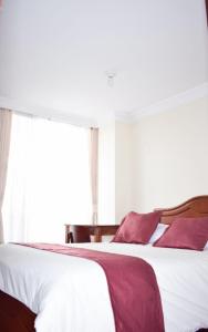 1 dormitorio con 1 cama grande y ventana en Hotel Sello Dorado, en Pasto