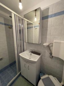 a bathroom with a sink and a toilet and a mirror at Erginas Boat House in Plaka Milou