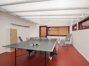 a ping pong table in a room with chairs at Recroy in Nedd