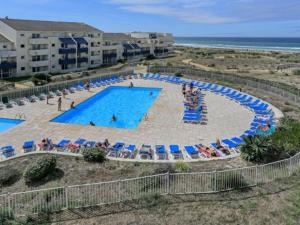 uma vista superior de uma piscina num resort em Appartement Climatisé avec Piscine & Mer Bleu Marine em Lacanau-Océan