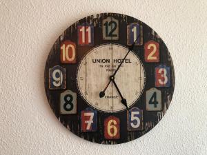 um relógio preto com números na parede em Appartement Climatisé avec Piscine & Mer Bleu Marine em Lacanau-Océan