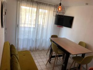 Et tv og/eller underholdning på Appartement Climatisé avec Piscine & Mer Bleu Marine